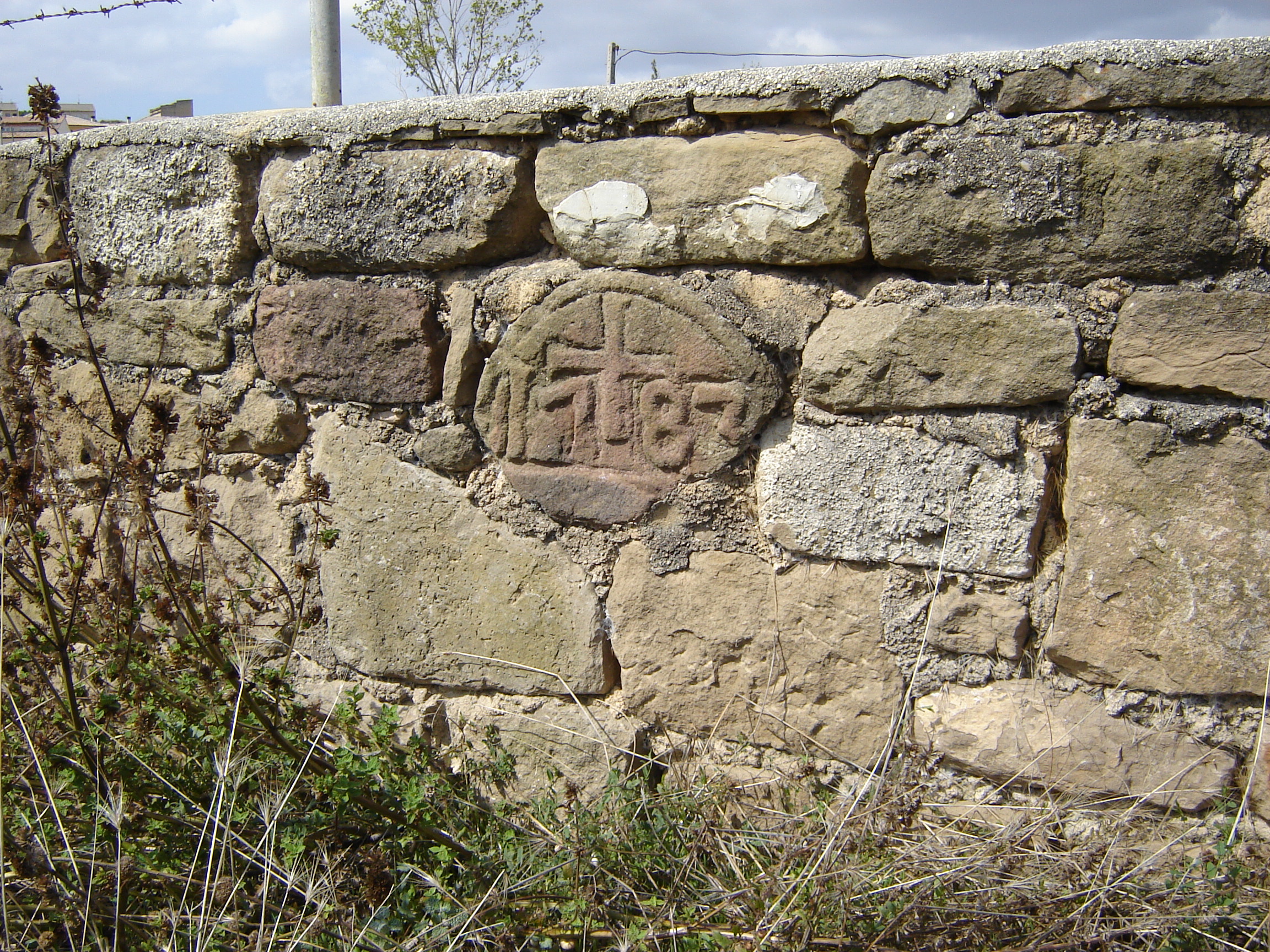 Caseta de Eguinoa. Murete que aprovecha parte de una lápida con una cruz y el año 1783 inscritos. (JAV)