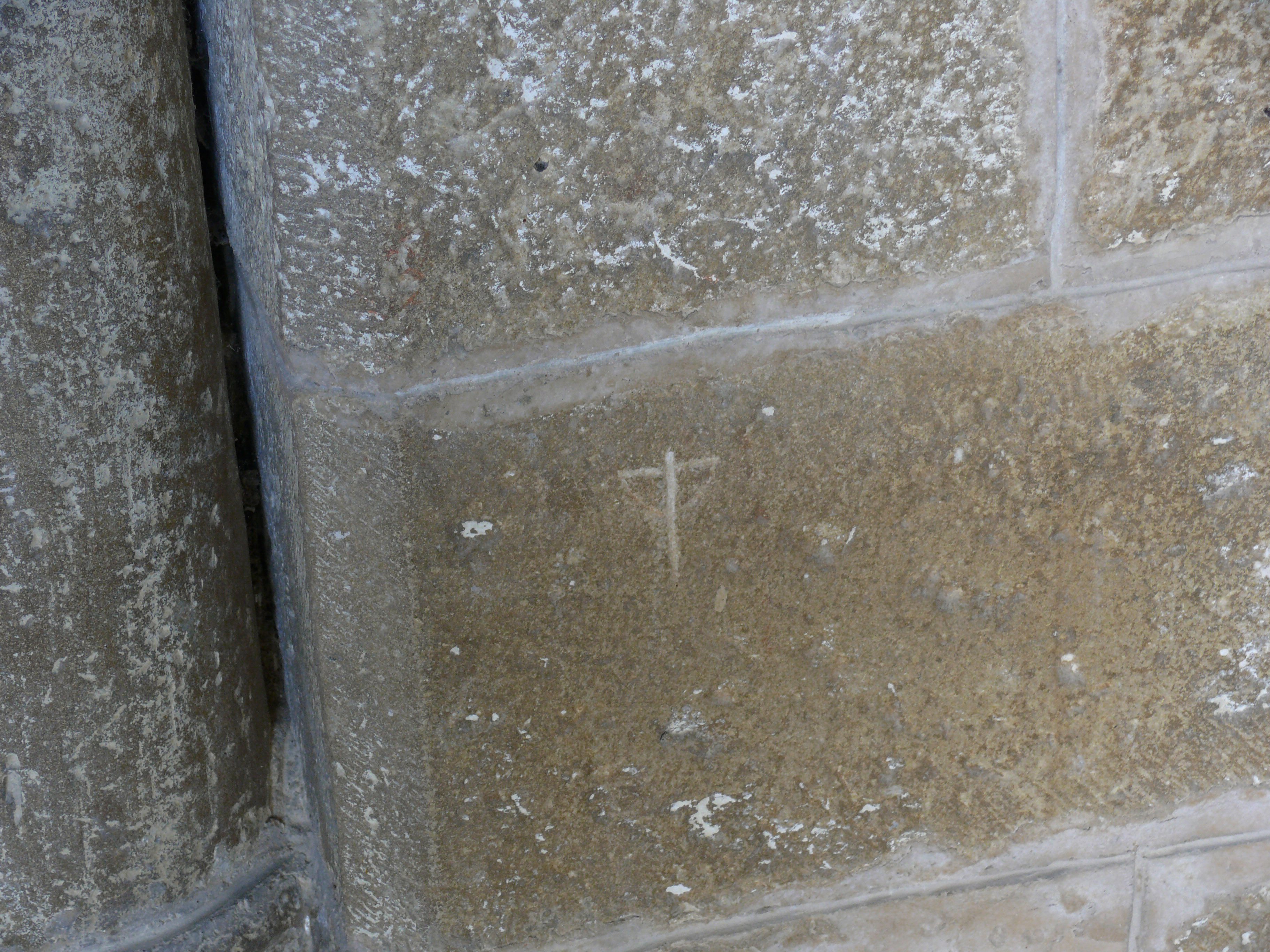 Pequeña cruz grabada junto a la entrada de la iglesia, en su lado izquierdo.